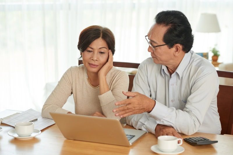 unhappy senior couple discussing their budget together.