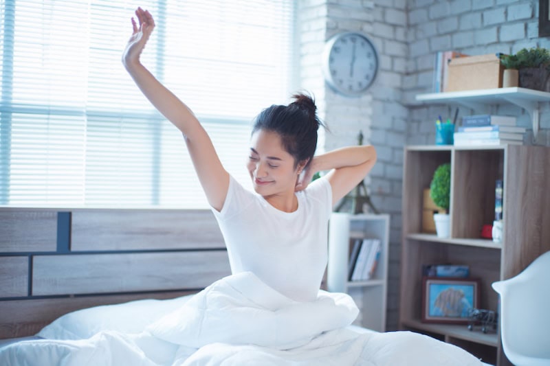 Woman stretching in bed.