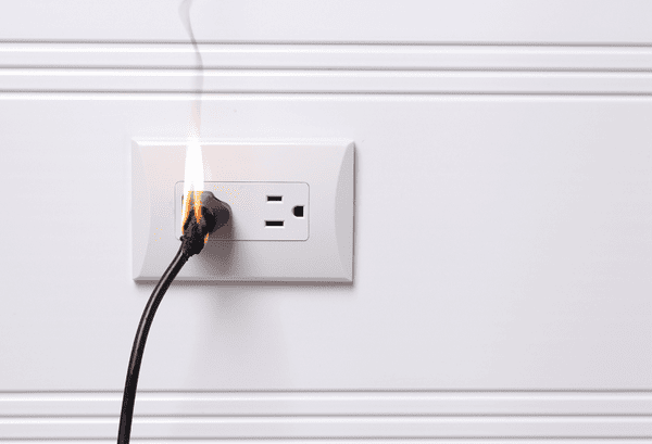 Image of outlet on fire. Electrical Surges Can Shock Your Wallet.